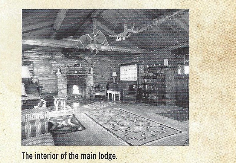 Interior of Elephant Head Lodge main lodge with antler mount, stone fireplace, and handwoven rugs